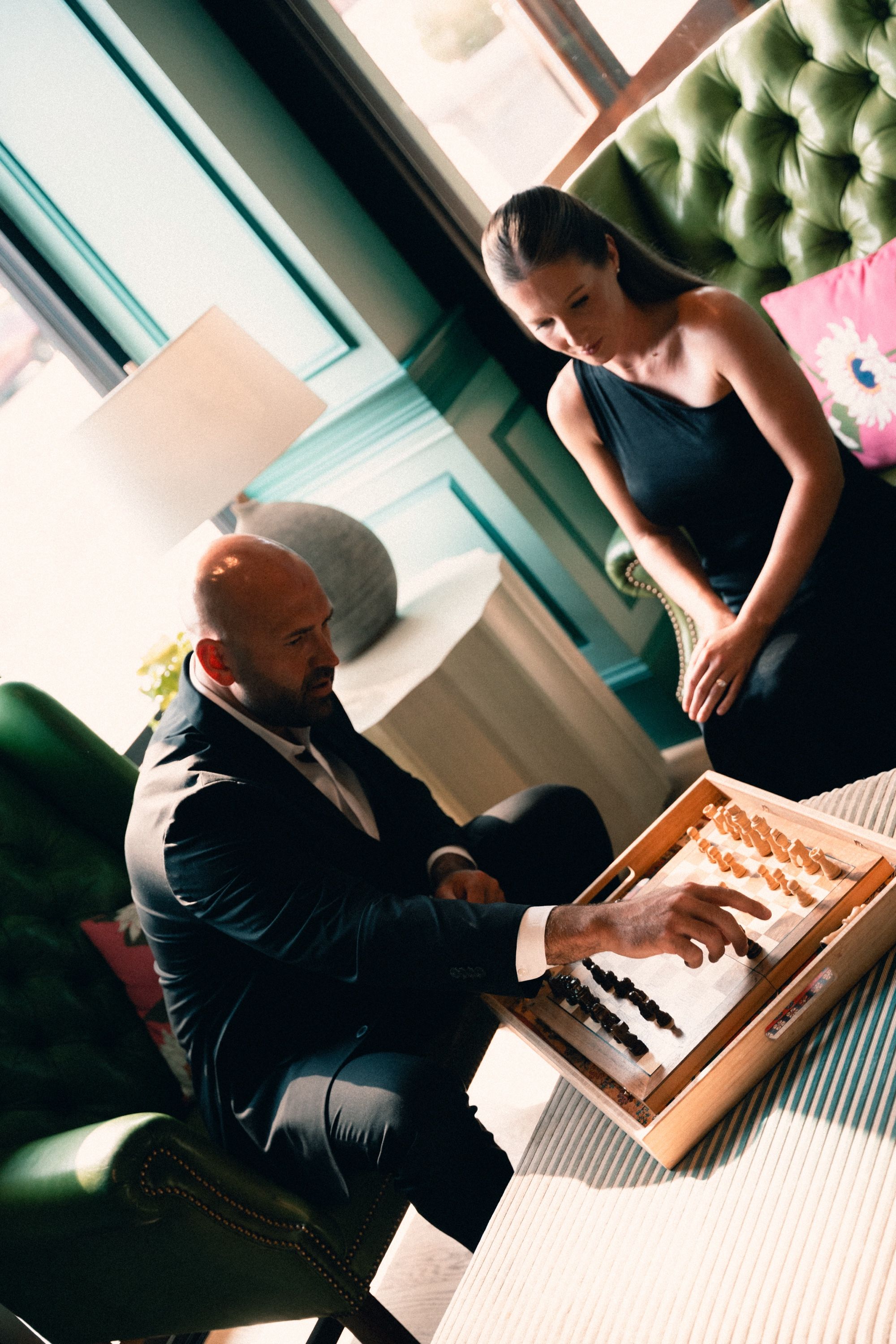 Couple playing chess on green chairs, Memphis engagement photography by Atkinson Studio