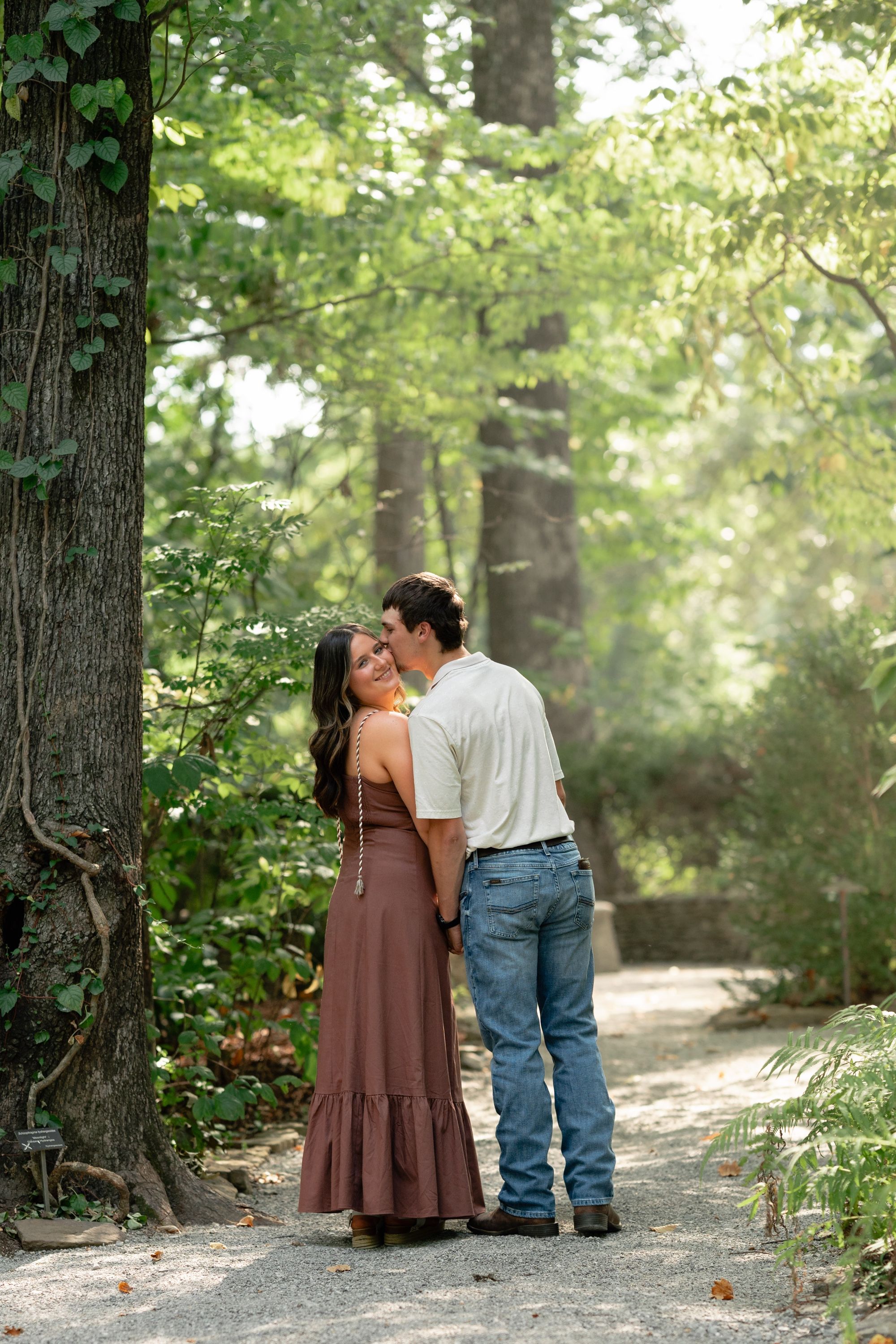 Engagement session kiss on a forest path, Memphis engagement photography by Atkinson Studio
