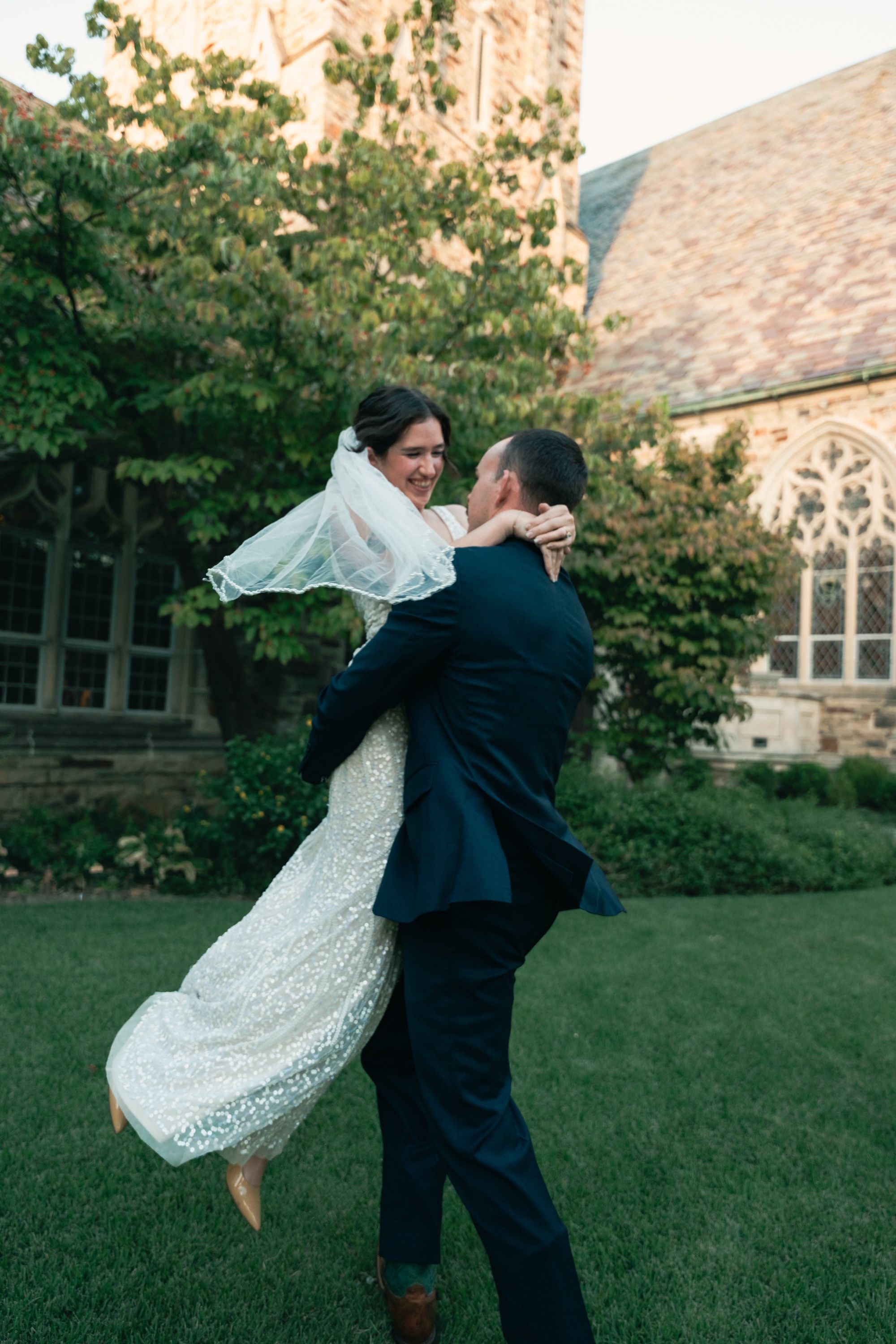 Groom lifting his laughing bride, her veil flying, Memphis wedding photography by Atkinson Studio